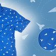 Load image into Gallery viewer, A complete view of the adult 7-Strong "Paper Planes" button down shirt - featuring various sizes and designs of paper airplanes, some with dotted trails behind them against a royal blue background. The shirt is displayed against a faced background of the shirt details. Bottom right features a detail circle highlighting the shirt design.