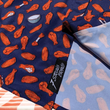 Load image into Gallery viewer, Bottom sweep tag view of the 7-Strong "Wingman" shirt, featuring various different flat and drum chicken wings and dip sauces on a deep blue background. Shirt is featured against a picnic/park background.