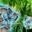 Load image into Gallery viewer, 3/4 upclose view of the 7-Strong "Tropic of Conversation" adult button down shirt - featuring several different floral plants in large, vibrant print against a faded background of other plants and florals. The shirt is featured against a lush, green rainforest background. The bottom right corner features a detail circle with up close look at the shirt design.