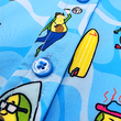 Load image into Gallery viewer, Midsection button view of the 7-Strong Avocado Coast button down featuring various avocado characters engaging in summer activities such as grilling, playing volleyball, weightlifting, surfing, etc against a blue shimmery wave looking background.