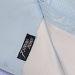 Load image into Gallery viewer, Bottom sweep tag view of the baby blue long sleeve EveryWEAR adult button up. Pattern is subtle white 7-Bolts lined up all against each other across a baby blue background. The shirt is featured on a soft background of a wave hitting the beach.