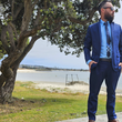 Load image into Gallery viewer, Shot of a male model, on a beach path looking off into the distance in a blue suit accented by the 7-Strong EveryWEAR collection baby blue long sleeve shirt.