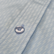 Load image into Gallery viewer, Close up mid button view of the baby blue short sleeve EveryWEAR adult button up. Pattern is subtle white 7-Bolts lined up all against each other across a baby blue background. The shirt is featured on a soft background of a wave hitting the beach.