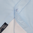 Load image into Gallery viewer, Bottom sweep tag view of the baby blue short sleeve EveryWEAR adult button up. Pattern is subtle white 7-Bolts lined up all against each other across a baby blue background. The shirt is featured on a soft background of a wave hitting the beach.