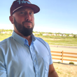 Load image into Gallery viewer, Medium shot of a male model, with an outdoor background, looking into the camera sporting the baby blue short sleeve EveryWEAR adult button down.