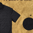 Load image into Gallery viewer, 3/4 close up view of the 7-Strong Bandido shirt, a black and gray paisley shirt design with black pearl snap buttons. Shirt is featured against a sepia toned parchment paper resembling a "wanted" sign. Bottom right corner has a close-up circle showing the paisley shirt detail.