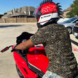 Load image into Gallery viewer, Person wearing a motorcycle helmet and the 7-Strong Bruce Leroy button down featuring gold dragons on a black background, sitting on a red motorcycle in a driveway.