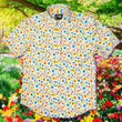 Load image into Gallery viewer, A full, centered close-up shot of the 7-Strong "Daisy Me Rollin'" adult button down shirt, a white base color with various blue, red, orange, and yellow floral daisies in an all over print. The shirt is displayed against a background of a field of daisies.