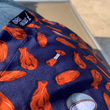 Load image into Gallery viewer, Sweep tag view of seated model wearing the 7-Strong "Wingman" shirt, featuring various different flat and drum chicken wings and dip sauces on a deep blue background.
