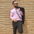 Load image into Gallery viewer, Medium view of a male model sporting the pink long short sleeve EveryWEAR adult button up, matched with a black suit. Pattern is subtle white 7-Bolts lined up all against each other across a pink background.
