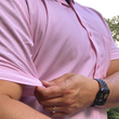 Load image into Gallery viewer, Medium shot of a male model tugging on sleeve of the pink short sleeve EveryWEAR adult button up. Pattern is subtle white 7-Bolts lined up all against each other across a pink background.