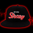 Load image into Gallery viewer, Full centered look at the Black 7-Strong Sideline Script hat, with white embroidered SEVEN and red puff scripted STRONG across the front. Hat is on the back of a red and black fusion background.