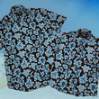 Load image into Gallery viewer, Overlapping view of the 7-Strong youth and adult Electric Palms shirts, a collection of electric blue palm fronds featured against a black shirt. Shirt is displayed against a scenic beach background.