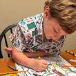 Load image into Gallery viewer, Child model sitting a dining room table coloring, wearing the 7-Strong Class Act youth button down.