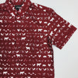 Load image into Gallery viewer, A 3/4 full view of the 7-Strong adult "Smoke Show" button up, a deep maroon red colored shirt with rows of various barbecue and cookout related items and delicacies silhouetted in white.