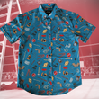 Load image into Gallery viewer, Full view of the 7-Strong "TLC OMG" shirt, a homage to wrestling objects featured all over the shirt including tables, ladders, chairs, ring bells, sledgehammers, brass knuckles, championships, guitars, stop signs, microphones amongst other items. The items are on a blue shirt with a faded steel cage background. The shirt is featured on a background of a wrestling ring with a standing ladder.