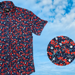 Load image into Gallery viewer, 3/4 full view of the 7-Strong "Aye Poppy" button down, featuring an array of red poppys with white sprigs on a deep navy blue shirt. The shirt is displayed against a partly cloudy sky. The bottom right has a detail circle featuring a close up of the design.