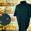 Load image into Gallery viewer, Full display view of the 7-Strong "Straight Sippin'" Short Sleeve button down. The shirt is a deep green with black ripples as its background, while the foreground has various drinking glasses with various levels of whiskey, some with ice, others without. The shirt is shown against a background of various whiskies and bourbons on a shelf. In the left corner, there is a detail circle showcasing the shirt's glass designs, up close.