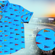 Load image into Gallery viewer, 3/4 view of the 7-Strong "Pennant to Win It" shirt, which is sky blue with texture, featuring various triangular flags featuring baseball's prominent cities patterned throughout. The shirt is featured against abackground is sunset at a major league stadium. The bottom right corner feature a close-up circle showing details of the pennant flags featured on the shirt.