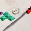 Load image into Gallery viewer, Close up of the middle button portion of the Block Party shirt detailing the various colored blocks of different arrangements inspired by a classic video game, cascading down the shirt against a grayish background featuring shadows of the same shapes. The shirt is presented on a background of similar design.