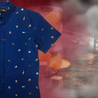 Load image into Gallery viewer, 3/4 layout, right justified of "Call Me Old Fashioned" adult short sleeve button-down. Features elements of an Old Fashioned cocktail (bottle of bourbon, glasses, oranges, stirrers, and ice) against a blue background which faintly spells out an Old Fashioned recipe. Shirt is on a background featuring a finished Old Fashioned.