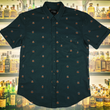 Load image into Gallery viewer, Full display view of the 7-Strong "Straight Sippin'" Short Sleeve button down. The shirt is a deep green with black ripples as its background, while the foreground has various drinking glasses with various levels of whiskey, some with ice, others without. The shirt is shown against a background of various whiskies and bourbons on a shelf.