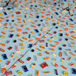 Load image into Gallery viewer, 3/4 angled mid-shirt view of the 7-Strong "Cheat Day" adult button down featuring various snacks, treats, and fast food features on a light blue shirt. The shirt is displayed against a background of a gym weight rack.