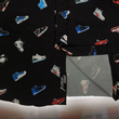 Load image into Gallery viewer, Bottom sweep tag view of the adult short sleeve version of "Got 'Em!" The button down features various athletic fashion sneakers in an 8-bit format arranged all over a black shirt. The shirt is featured against a background of a basketball player on the court, noticeable sneakers being worn