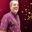 Load image into Gallery viewer, Cheering male model sporting the Cup of Life adult button up, a off-maroon colored shirt decorated throughout with falling gold confetti and depictions of the World Cup statue. The models are standing against a confetti background that matches the shirt design.