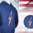 Load image into Gallery viewer, Full view of the navy blue Freedom Bolt hoodie, featured on a mannequin and showcasing a gold outlined 7-bolt with white stars on blue on top and red and white stripes on the bottom. The hoodie is featured on an American flag background. There is a detail circle in the bottom right circle featuring the 7-Bolt on the hoodie.