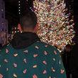 Load image into Gallery viewer, Adult male model wearing long-sleeve "Oh, Christmas Treat" shirt with a green, christmas sweater-like background with columns of various white Christmas tree shaped cakes with red garland, some whole, some bitten. Model is standing in front of a Christmas Tree.