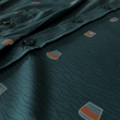 Load image into Gallery viewer, Midsection buttons and sleeve view of the 7-Strong "Straight Sippin'" long Sleeve button down. The shirt is a deep green with black ripples as its background, while the foreground has various drinking glasses with various levels of whiskey, some with ice, others without.