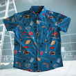 Load image into Gallery viewer, Full view of the youth 7-Strong "TLC OMG" shirt, a homage to wrestling objects featured all over the shirt including tables, ladders, chairs, ring bells, sledgehammers, brass knuckles, championships, guitars, stop signs, microphones amongst other items. The items are on a blue shirt with a faded steel cage background. The shirt is featured on a background of a wrestling ring with a standing ladder.