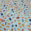 Load image into Gallery viewer, 3/4 angled button area view of the 7-Strong "Cheat Day" youth button down featuring various snacks, treats, and fast food features on a light blue shirt. The shirt is displayed against a background of a gym weight rack