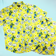 Load image into Gallery viewer, Full view of both 7-Strong "Late Bloomer" adult and youth button downs overlapping one another - a yellow background shirt with white and blue flowers patterned all over it. Shirt is against a blue tropical sky with palm trees in the distance.