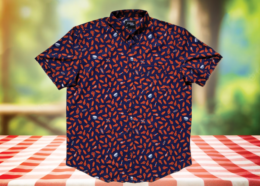 Full centered view of the 7-Strong "Wingman" shirt, featuring various different flat and drum chicken wings and dip sauces on a deep blue background. Shirt is featured against a picnic/park background.