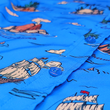 Load image into Gallery viewer, Close up, middle button view of the 7-Strong &quot;7-Seas&quot; shirt, a bright blue colored shirt with various nautical depictions such as islands, ships, mermaids, etc - drawn in a treasure map like fashion.
