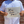 Load image into Gallery viewer, A midsection view of a male model wearing the 7-Strong &quot;Stay&quot; button down, a white shirt with staggered, hollowed out semicolons outlined in teal and purple - the colors for suicide awareness. Model is holding a handwritten sign saying &quot;You Got This!&quot;
