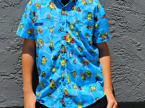 Male model, face not shown, against a gray stone wall, wearing the 7-Strong youth Avocado Coast button down, straight to camera. 