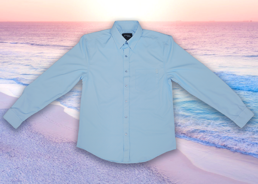 Full centered view view of the baby blue long sleeve EveryWEAR adult button up. Pattern is subtle white 7-Bolts lined up all against each other across a baby blue background. The shirt is featured on a soft background of a wave hitting the beach.