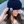 Load image into Gallery viewer, Female model smiling and looking away while wearing the black 7-Bolt beanie, reaching up to playfully adjust it. 
