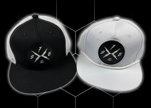 Both the black "Branded" trucker hat and the white "Branded" performance hat centered side-by-side against a black geometric background. Both feature raised black rubber X-Badge patches