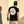 Load image into Gallery viewer, Male model with his back to the camera down an alley way, wearing the &quot;Branded&quot; black tee featuring the X-Badge logo centered in white on the back and wearing the &quot;Branded&quot; black trucker hat with the x-badge centered in black. 
