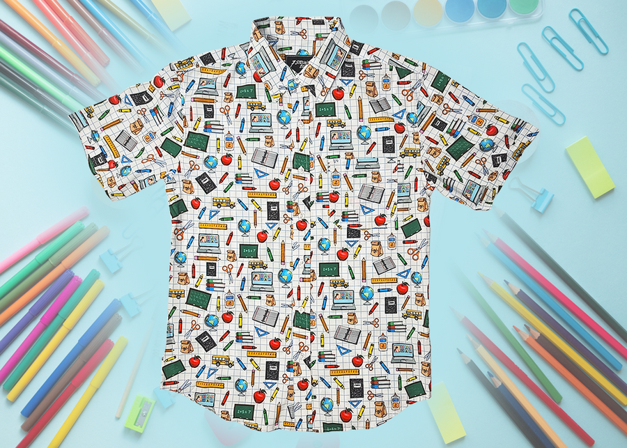 Full centered of 7-Strong Class act button-down featuring various classroom items such as pencils, rulers, globes, notebooks, apples, protractors, etc against a white graph paper background. Shirt is against a background of school supplies. 