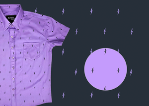 3/4 view of the youth 7-Strong Deep Lavender 7-Bolt short sleeve shirt, featuring black 7-bolts interspersed on a deep lavender background. The shirt is featured on a slate backdrop with lavender bolts. The bottom left features a detail circle showing the 7-bolt design up close.
