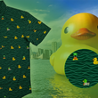Load image into Gallery viewer, A 3/4 view of the 7-Strong &quot;Duck O&#39; The Irish&quot; adult button down, featuring a deep green water-replicating background with various rubber ducks swimming along the waves. The shirt is featured against a green river scenic with a giant inflatable duck in the background. In the bottom right, there is a detail circle that shows the design pattern up close. 
