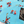 Load image into Gallery viewer, A bottom sweep tag view of the adult 8-Bit Hat Trick button down - featuring various 8-bit inspired scenes from hockey games on a light blue ice-like background. The shirt is featured against a ice hockey floor with hats strewn about. 

