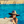 Load image into Gallery viewer, Shot of a child model in a pool wearing the 7-Strong &quot;Neon Coast&quot; Sun Hat, made from straw, which features the Neon Coast design in a patch on the front, with &quot;7-Strong Brand&quot; written across it. The pattern can also be seen lining the brim of the hat, along with the underside. A black strap keeps the hat in place. 
