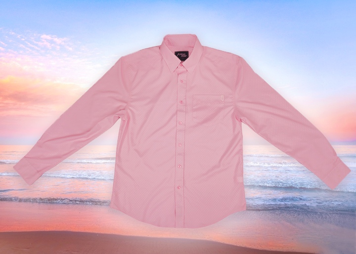 Full centered view of the pink short sleeve EveryWEAR adult button up. Pattern is subtle white 7-Bolts lined up all against each other across a pink background. The shirt is featured on a soft background of a wave hitting the beach.