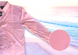 3/4 full view of the pink long sleeve EveryWEAR adult button up. Pattern is subtle white 7-Bolts lined up all against each other across a pink background. The shirt is featured on a soft background of a wave hitting the beach. Bottom right corner features a detail circle of the bolts up close.